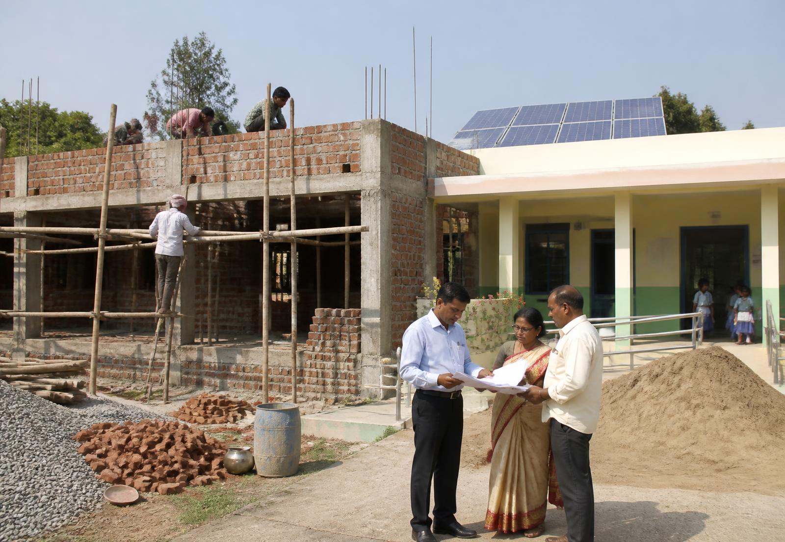 A new classroom block under construction beside the existing school building